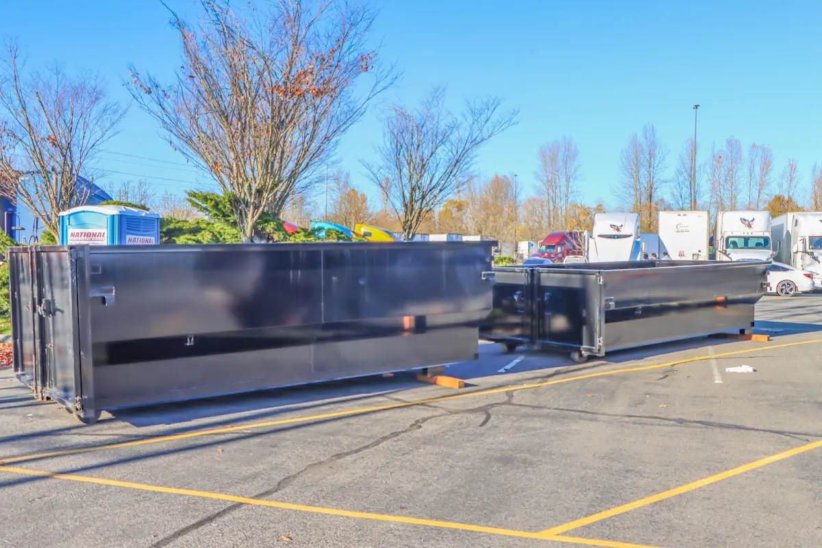 Professional dumpster rental service with roll-off container on residential driveway in Boxford